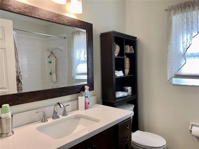 a bathroom with a toilet sink and mirror