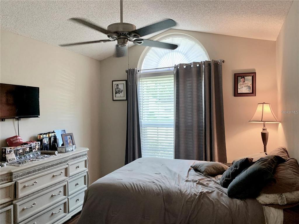 8553 Manassas Road Tampa, FL 33635 - Photo 26 of 33 a bedroom with a bed and a flat tv screen on dresser