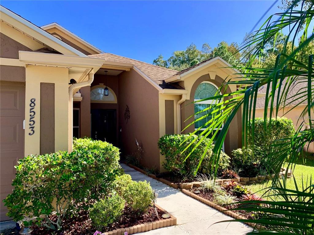 8553 Manassas Road Tampa, FL 33635 - Photo 3 of 33 a front view of a house with a yard