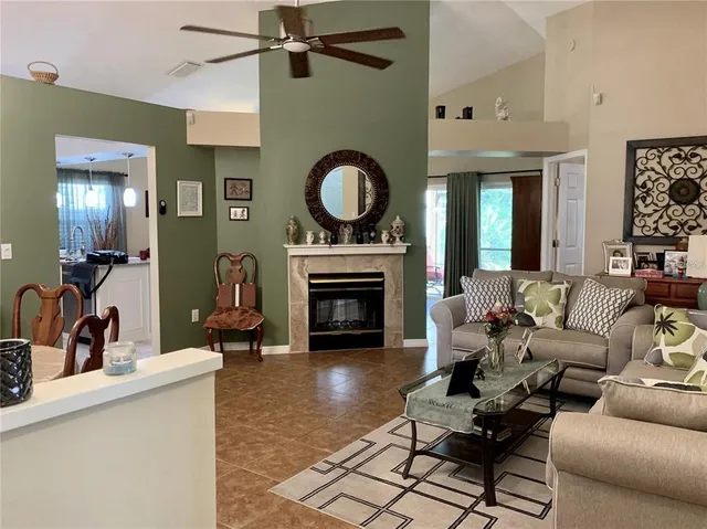 a living room with furniture a fireplace and a chandelier