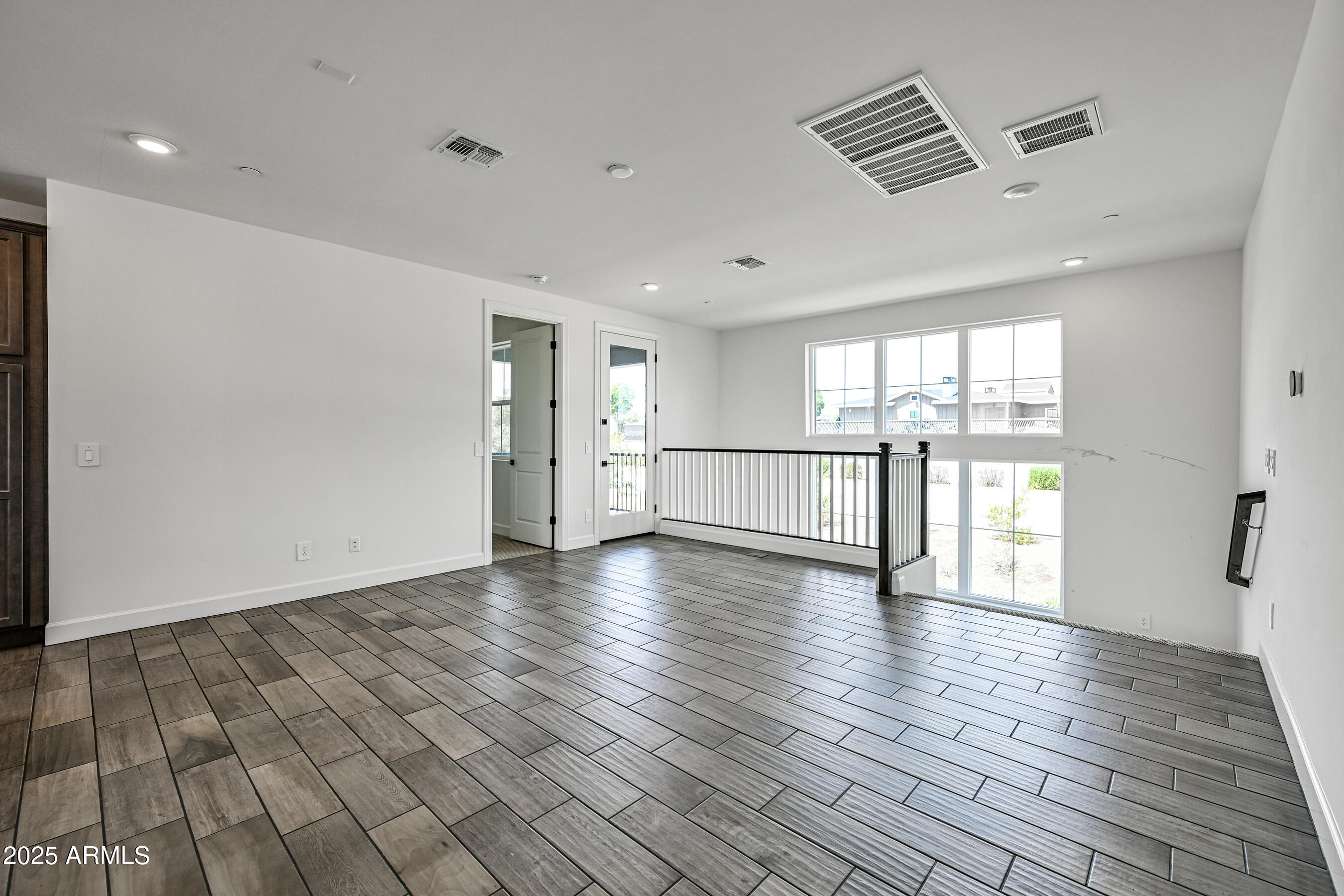 11300 North Casa Dega Drive, Unit 1061 Surprise, AZ 85388 - Photo 9 of 45 a view of an empty room with wooden floor and a window