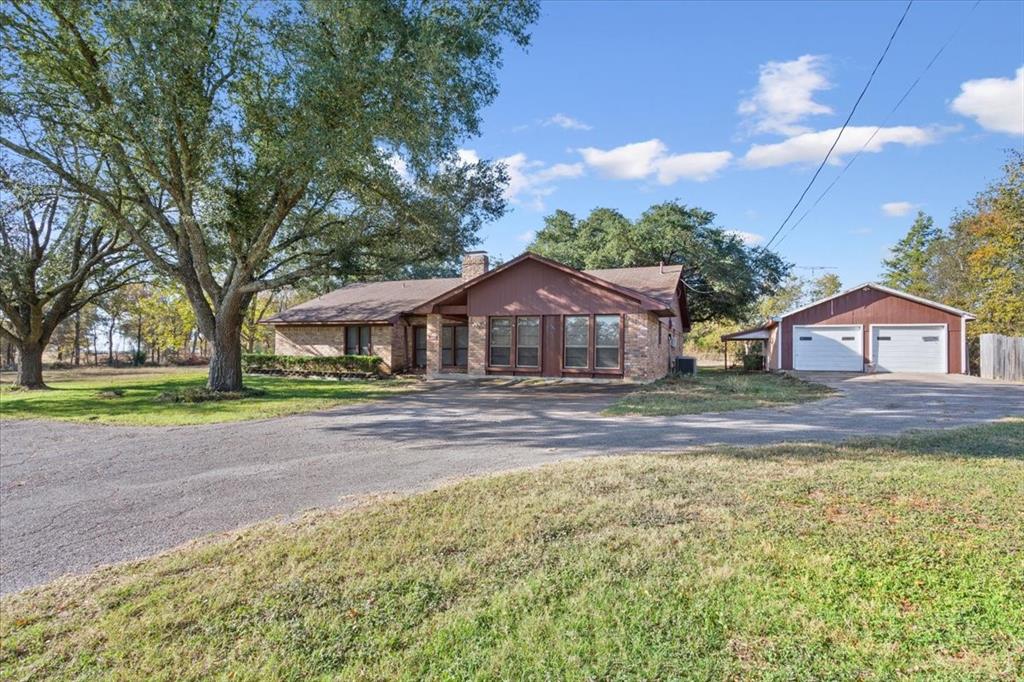 208 South Hedwig Street Riesel, TX 76682 - Photo 3 of 31 Single story home featuring an outbuilding, a detached garage, a chimney, and a front yard