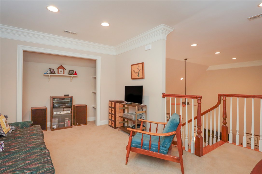 103 C-10-147D Anderson, SC 29621 - Photo 28 of 49 Recessed lighting illuminates this versatile bonus room, offering comfortable living space and a view of the adjacent staircase.