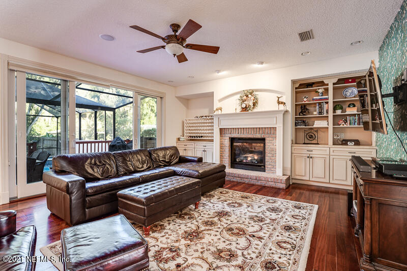 2710 Holly Point Road East Orange Park, FL 32073 - Photo 12 of 64 a living room with furniture a rug and a fireplace
