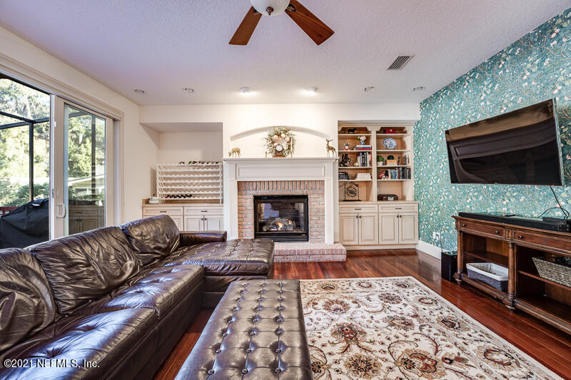 2710 Holly Point Road East Orange Park, FL 32073 - Photo 14 of 64 a living room with furniture flat screen tv and a fireplace