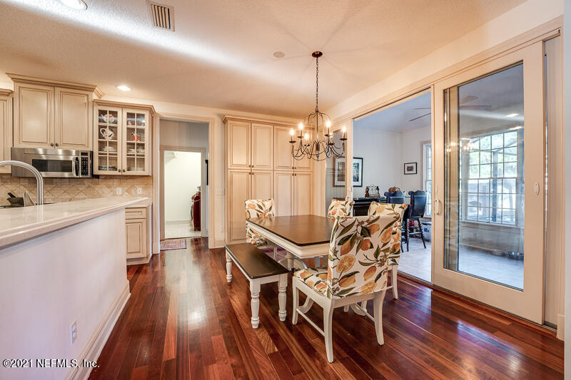 2710 Holly Point Road East Orange Park, FL 32073 - Photo 17 of 64 a view of a dining room and livingroom with furniture wooden floor a chandelier