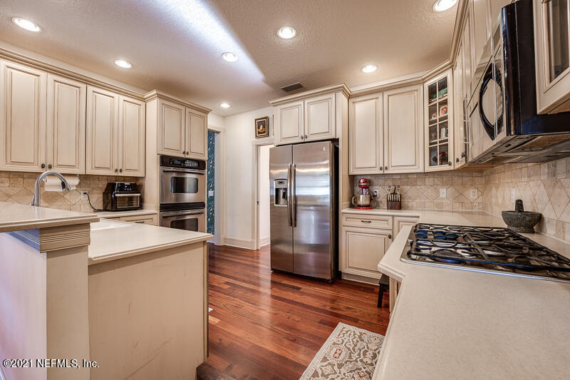 2710 Holly Point Road East Orange Park, FL 32073 - Photo 21 of 64 a kitchen with stainless steel appliances granite countertop a refrigerator stove and sink
