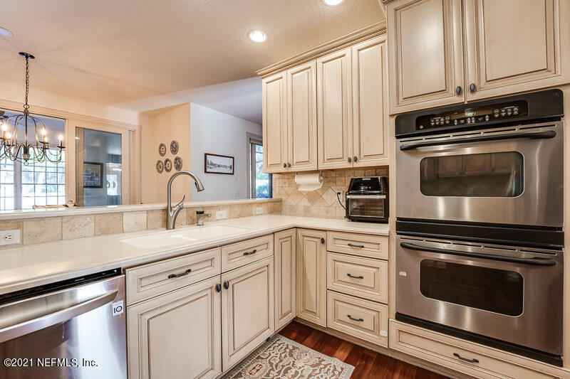 2710 Holly Point Road East Orange Park, FL 32073 - Photo 25 of 64 a kitchen with granite countertop white cabinets white stainless steel appliances and sink