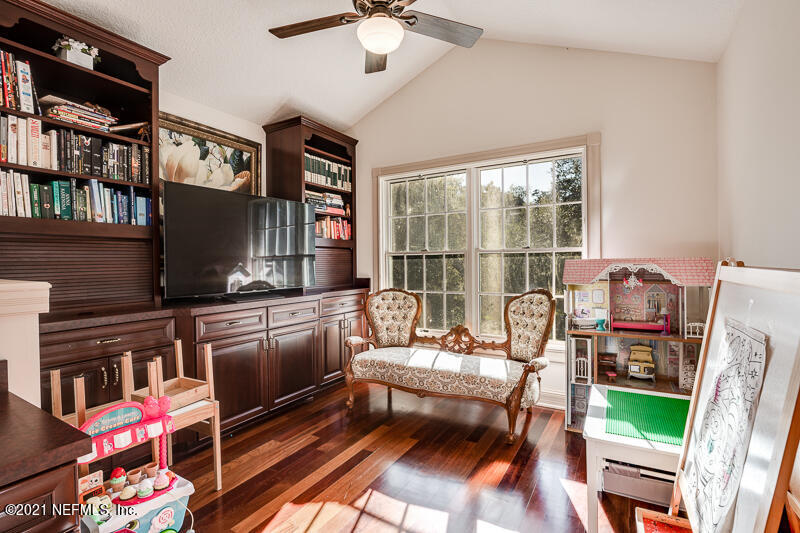 2710 Holly Point Road East Orange Park, FL 32073 - Photo 39 of 64 a living room with furniture a flat screen tv and a floor to ceiling window
