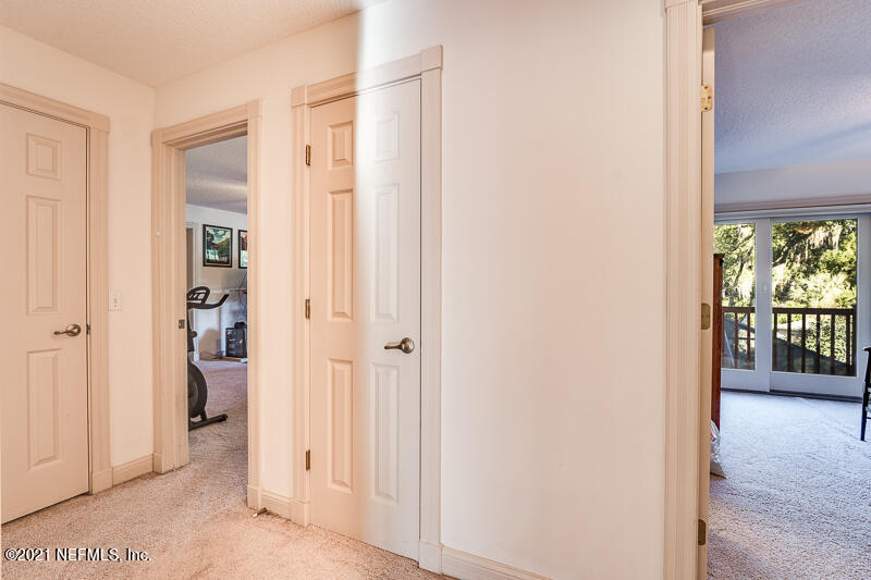 2710 Holly Point Road East Orange Park, FL 32073 - Photo 42 of 64 a view of a hallway with wooden floor and a livingroom
