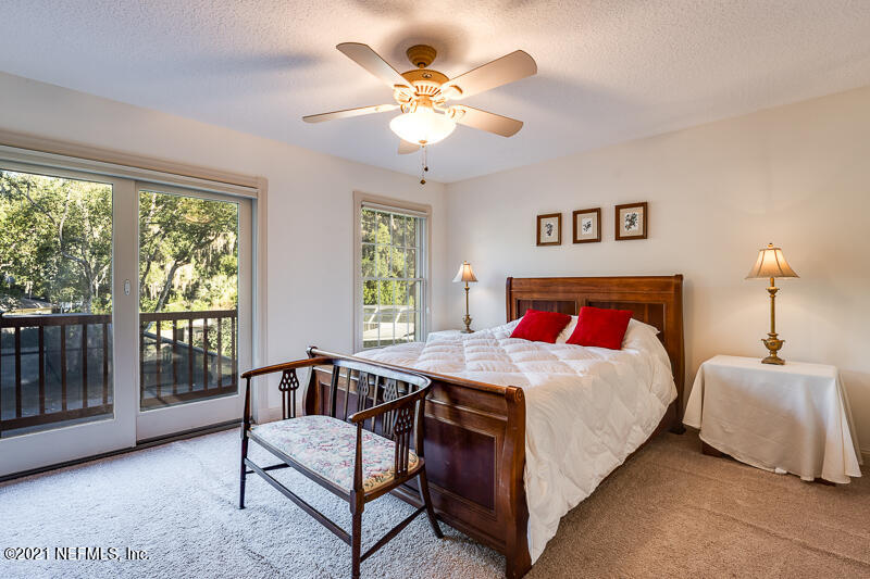 2710 Holly Point Road East Orange Park, FL 32073 - Photo 43 of 64 a bedroom with a bed and a chandelier