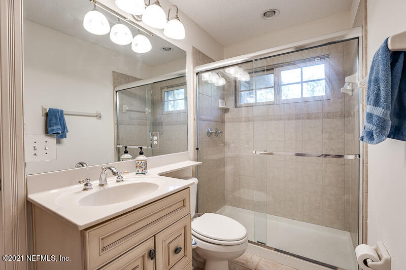 2710 Holly Point Road East Orange Park, FL 32073 - Photo 45 of 64 a bathroom with a sink toilet a mirror and shower