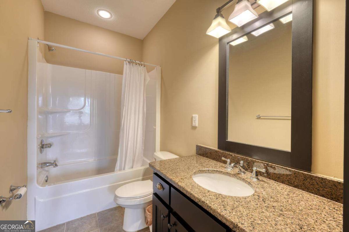 1401 Lakeside Road, Unit 502 Hiawassee, GA 30546 - Photo 24 of 46 a bathroom with a granite countertop sink toilet mirror and a bathtub