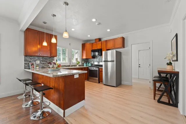 a kitchen with stainless steel appliances granite countertop a sink a stove and a refrigerator