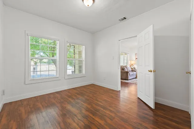 a view of an empty room with wooden floor