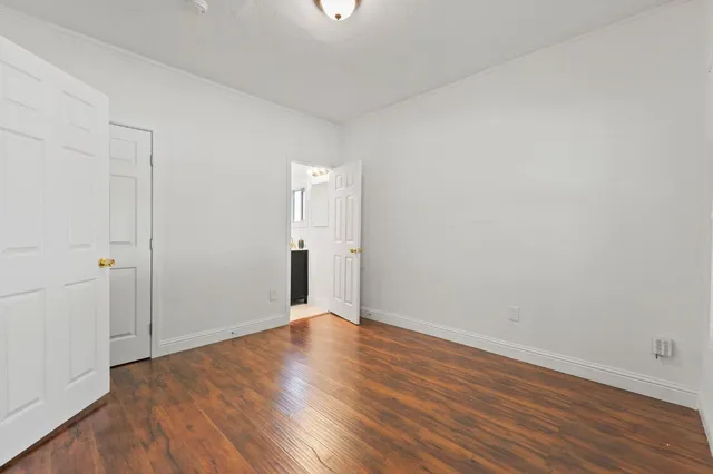 a view of empty room with wooden floor