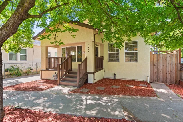 a view of a house with a small yard and wooden fence