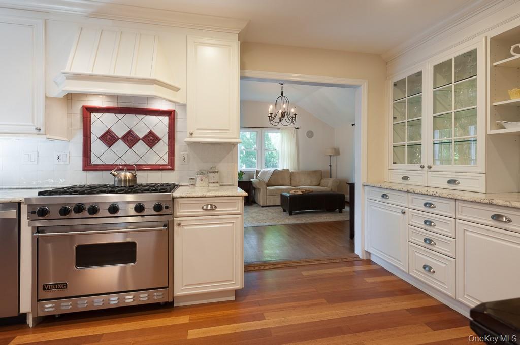 5 Sturgis Road Mount Vernon, NY 10552 - Photo 10 of 25 a kitchen with stainless steel appliances white cabinets and a wooden floor