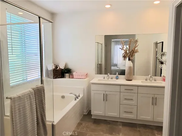 a bathroom with a double vanity sink a mirror and a bathtub