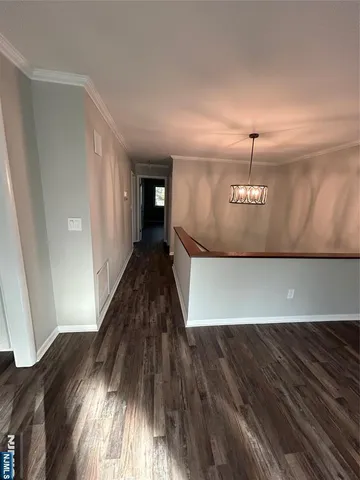 a view of empty room with window and wooden floor