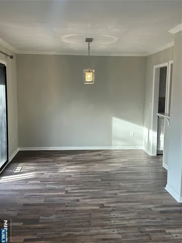 a view of empty room with wooden floor and fireplace