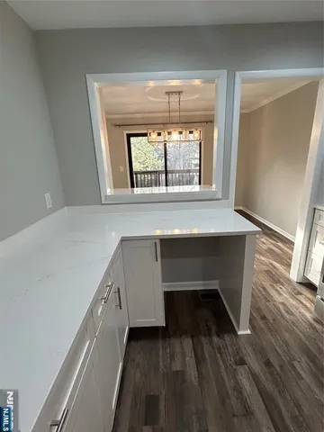 a kitchen with a sink a refrigerator and chairs