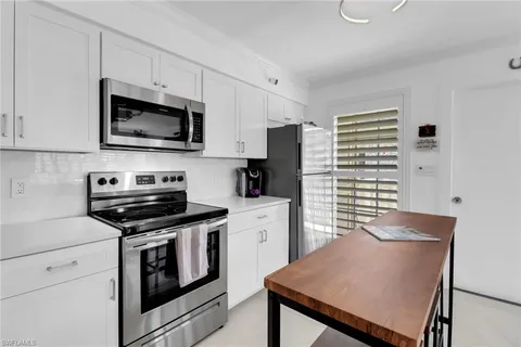 a kitchen with stainless steel appliances a stove microwave and refrigerator