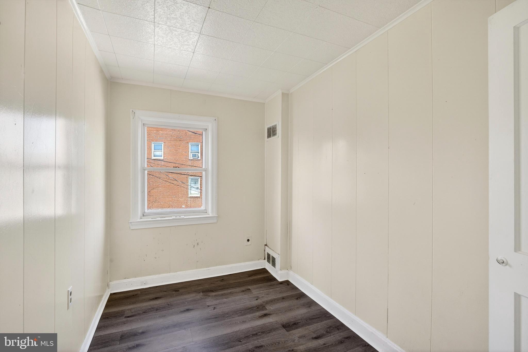 528 Sunset Road Baltimore, MD 21223 - Photo 15 of 27 an empty room with wooden floor and windows