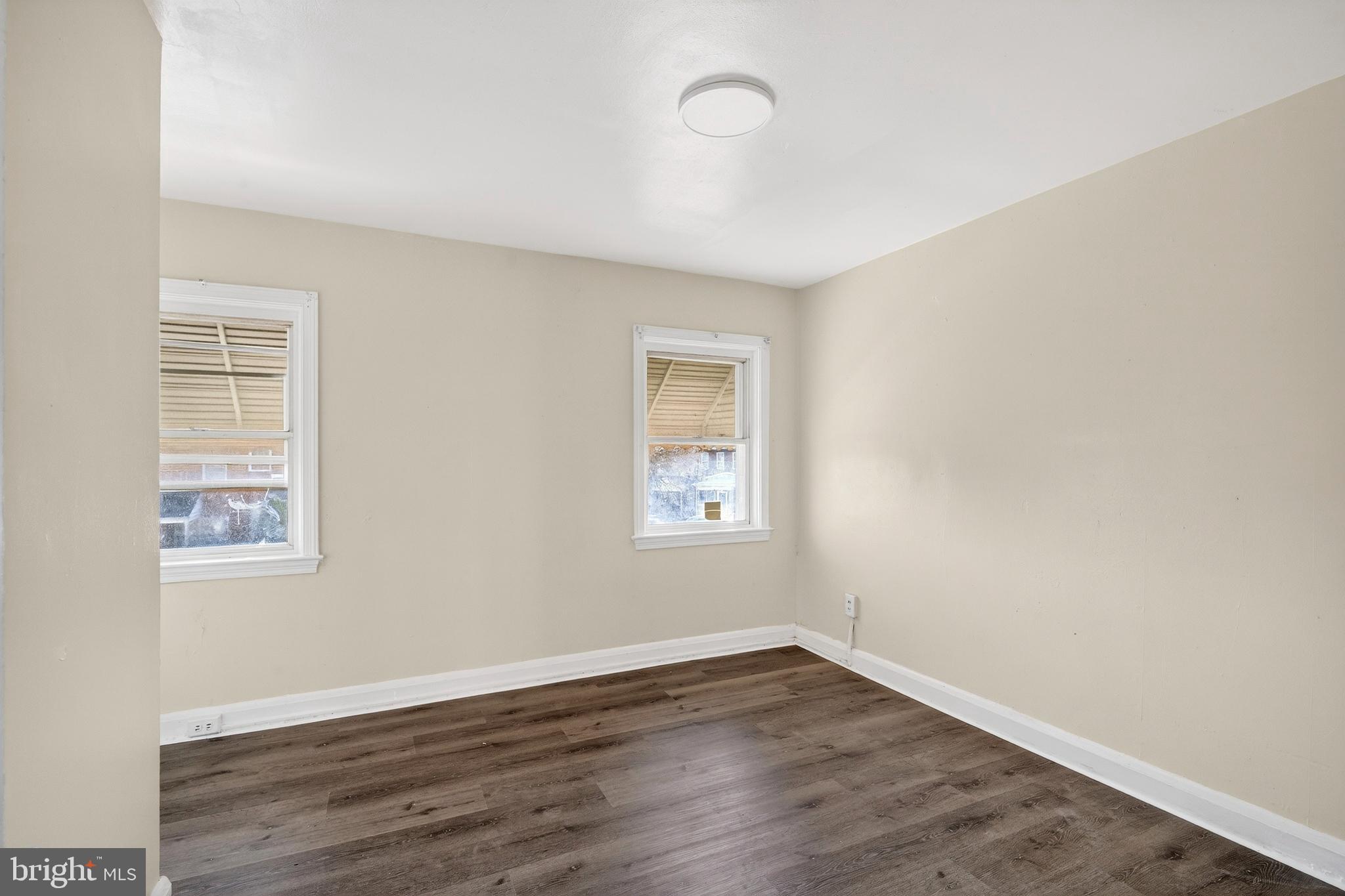 528 Sunset Road Baltimore, MD 21223 - Photo 8 of 27 an empty room with wooden floor and windows
