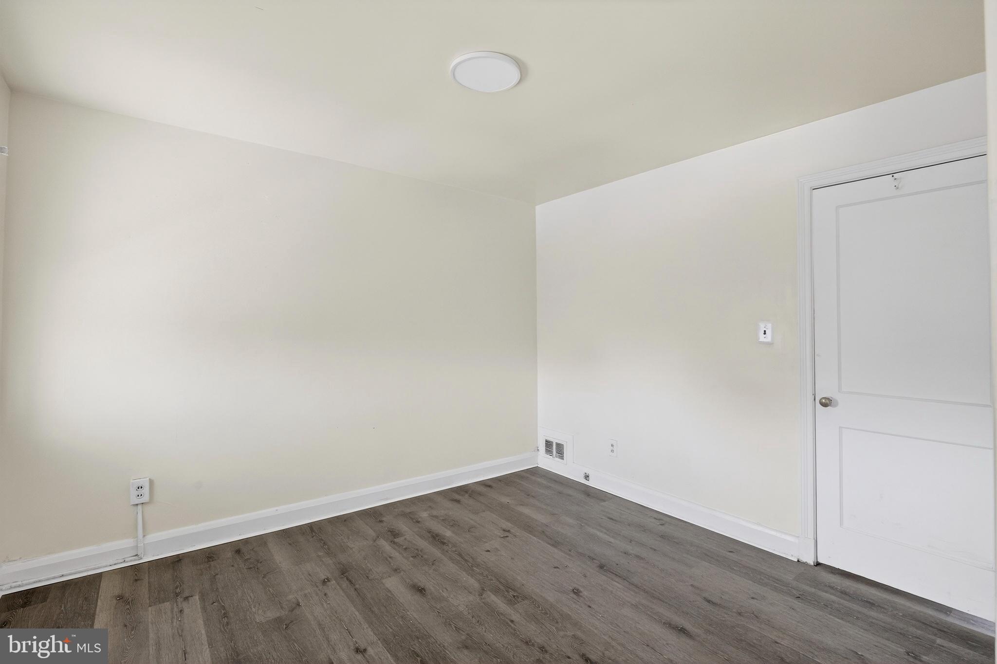 528 Sunset Road Baltimore, MD 21223 - Photo 9 of 27 an empty room with wooden floor and windows