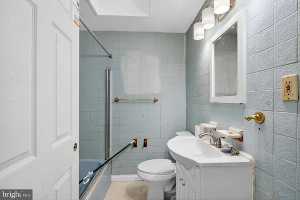 a bathroom with a sink toilet and a mirror