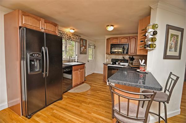 272 Main Street Norfolk, MA 02056 - Photo 5 of 29 a kitchen with granite countertop a refrigerator and a stove top oven
