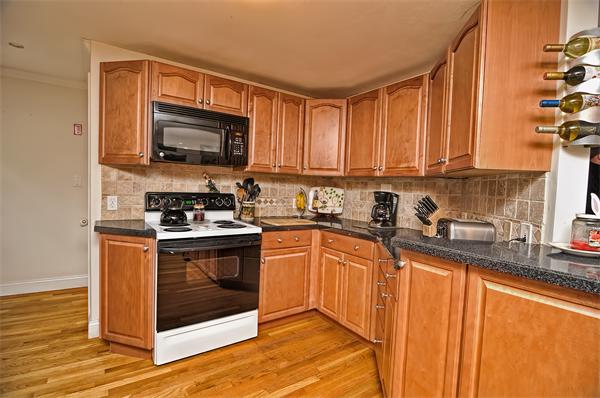 272 Main Street Norfolk, MA 02056 - Photo 6 of 29 a kitchen with stainless steel appliances granite countertop a stove a sink and a microwave