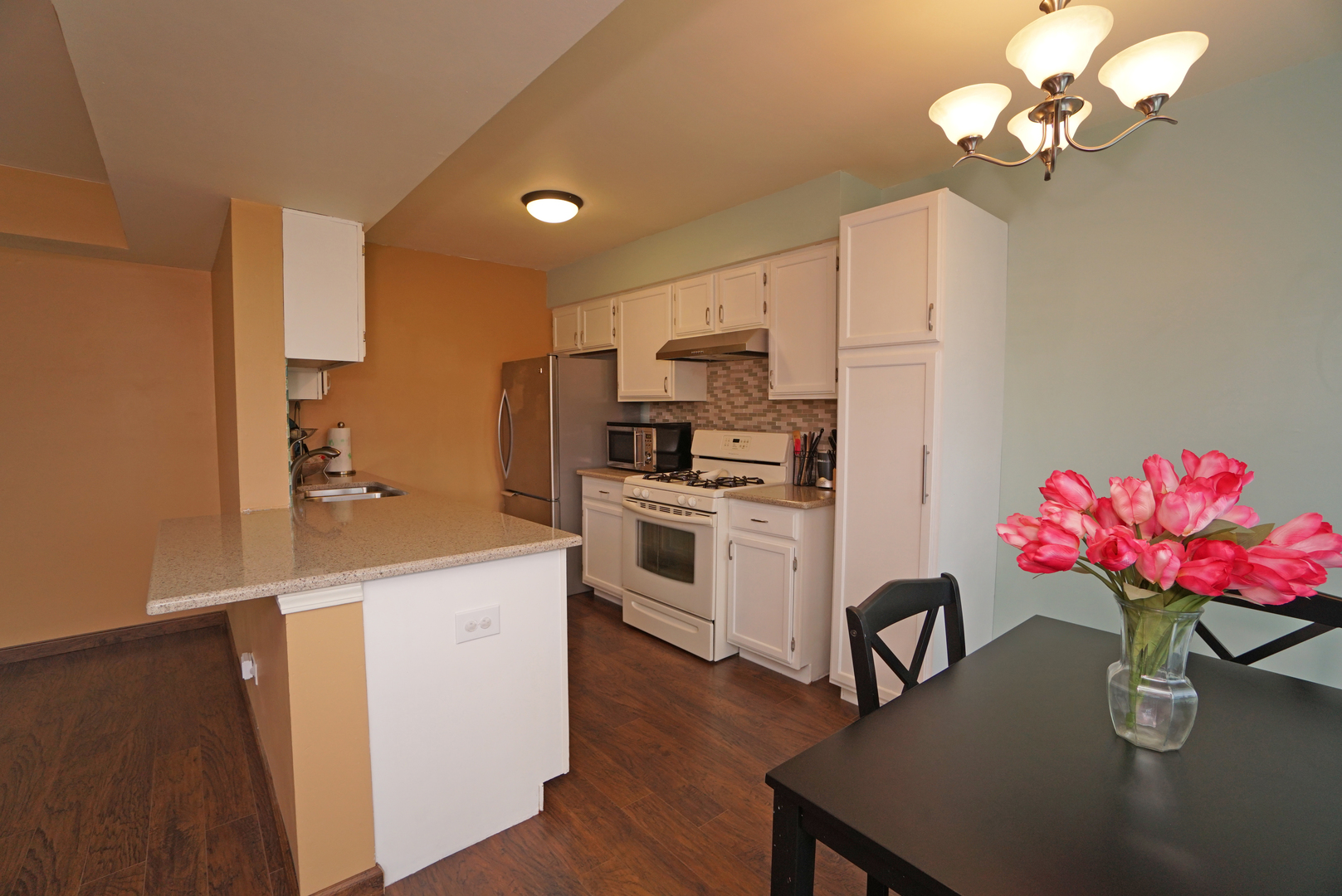 23 North Oltendorf Road Streamwood, IL 60107 - Photo 9 of 35 a kitchen with a white chandelier appliances and cabinets
