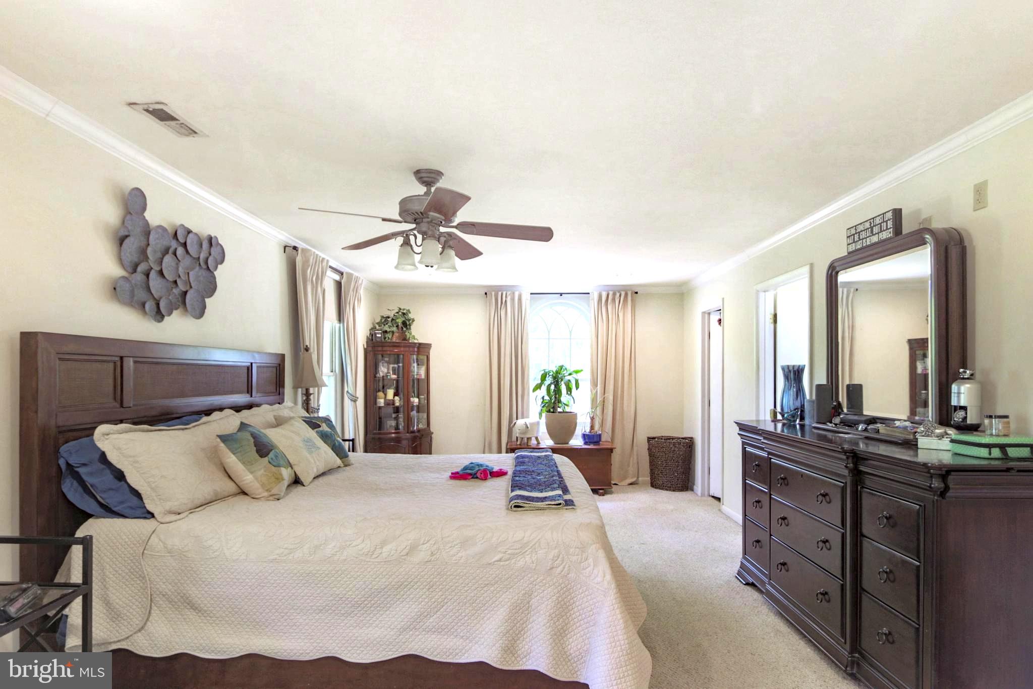 41 Wood Landing Road Fredericksburg, VA 22405 - Photo 7 of 54 a spacious bedroom with a large bed and a chandelier