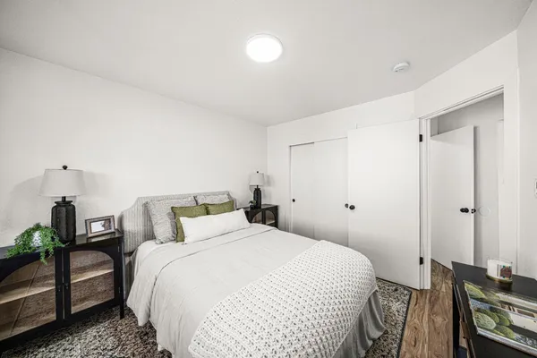a bedroom with a bed and wooden floor