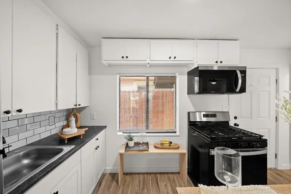 a kitchen with a sink a stove and cabinets