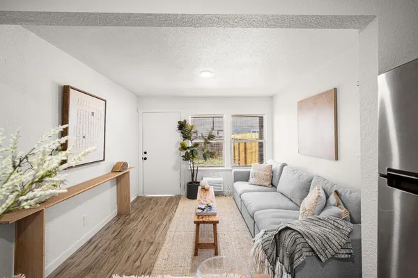a living room with furniture and a wooden floor