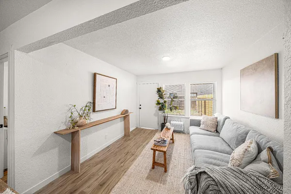 a living room with furniture and a wooden floor