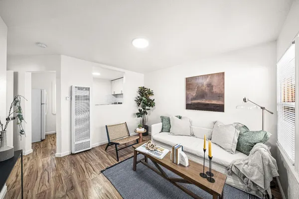 a living room with furniture and a wooden floor