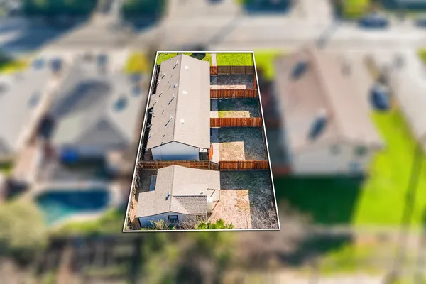 an aerial view of a house with a garden and trees