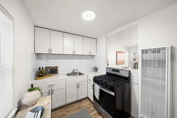 a kitchen with cabinets appliances a sink and a stove
