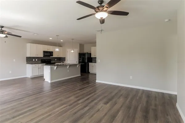 a view of kitchen with granite countertop stainless steel appliances and wooden floor