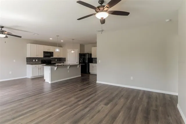 a view of kitchen with granite countertop stainless steel appliances and wooden floor