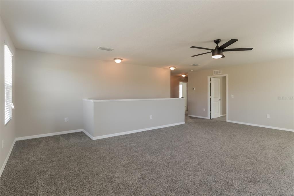 13628 Covey Run Place Spring Hill, FL 34609 - Photo 9 of 22 an empty room with a ceiling fan and window