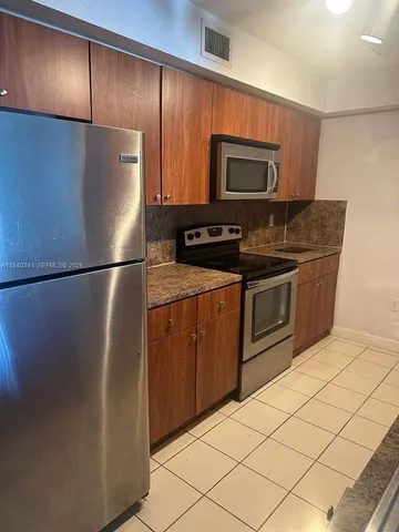 a kitchen with stainless steel appliances granite countertop a refrigerator and a stove top oven