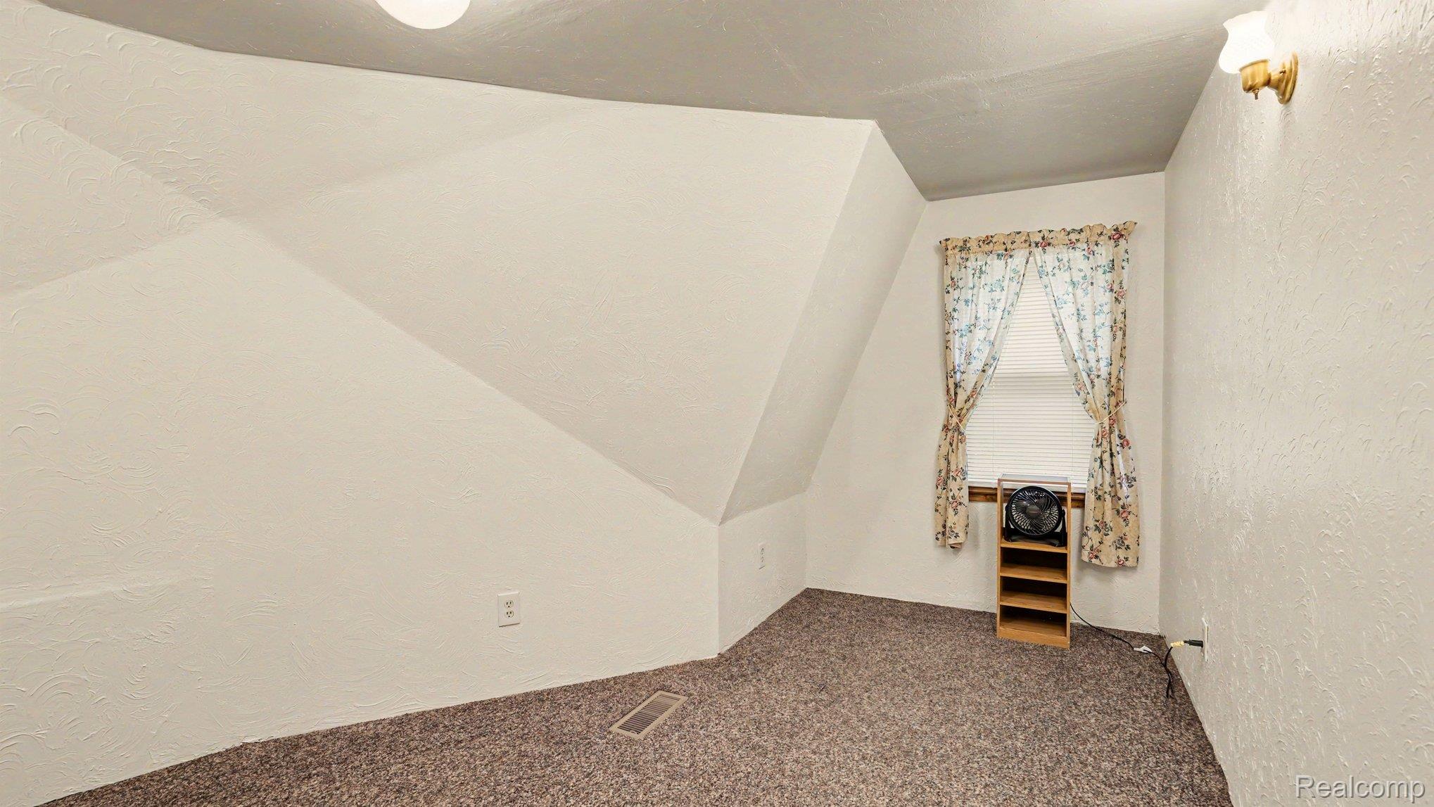 3700 Elbow Lake Road Prescott, MI 48756 - Photo 10 of 29 Carpeted flooring, sloped ceiling, window, and wall-mounted light fixture