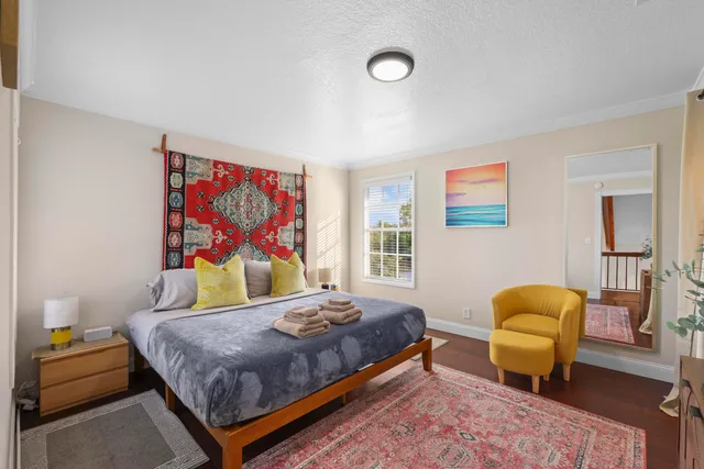 a bedroom with a bed and painting on the wall