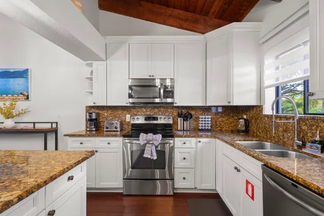 a kitchen with stainless steel appliances granite countertop a sink stove and cabinets