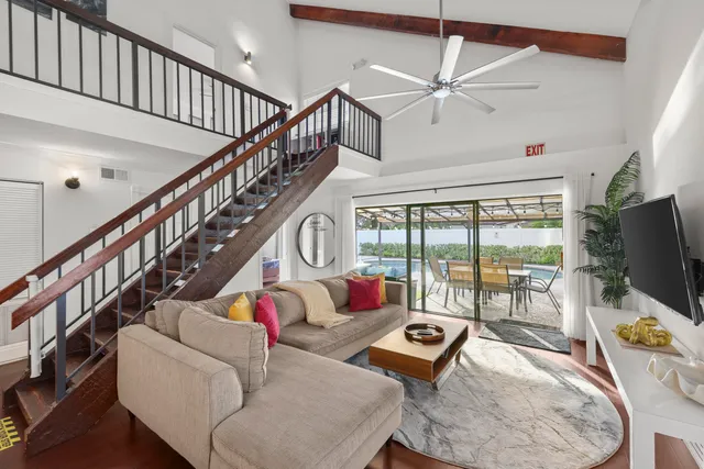 a living room with furniture flat screen tv and a large window